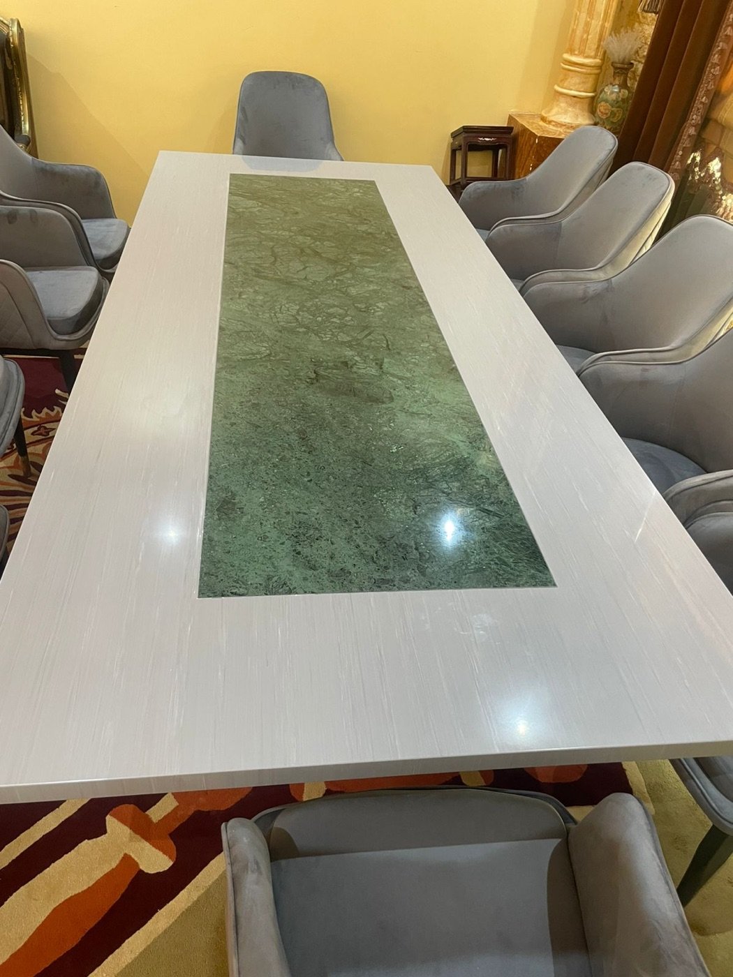 Solid-surface boardroom conference table with green marble inlay centre