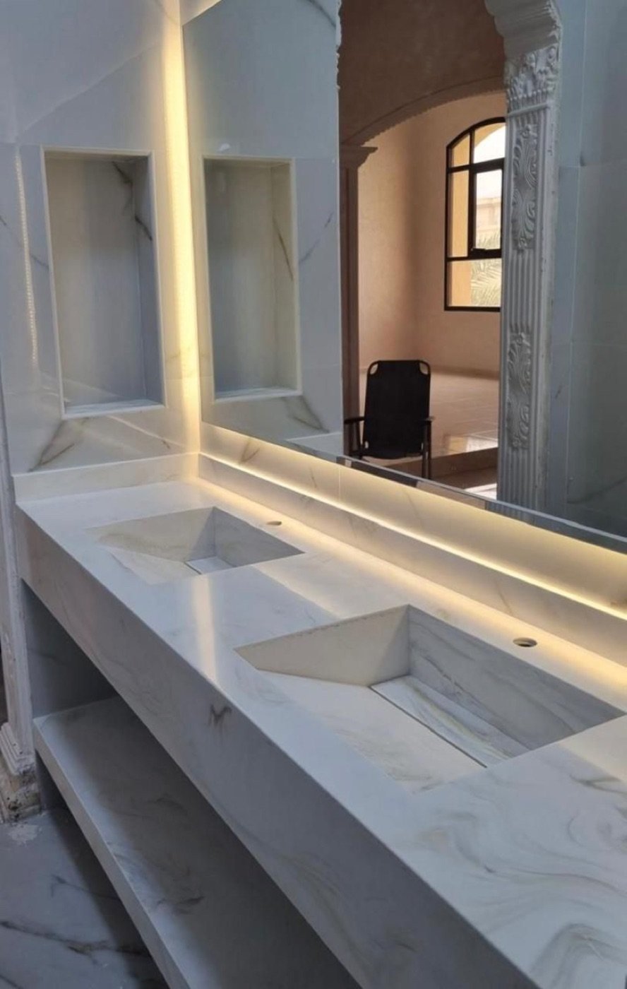 Corian hotel double vanity with integrated basins and backlit mirrors