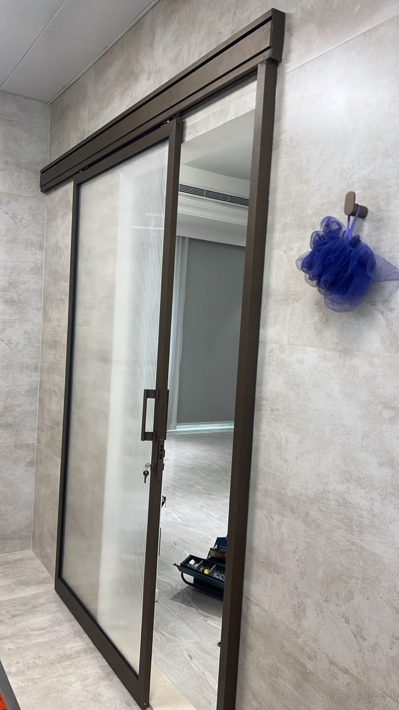 Fluted-glass sliding washroom door slid open on its top-hung track