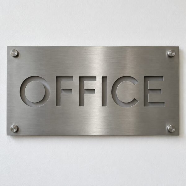Front view of a brushed stainless steel OFFICE sign plate with four standoff bolts on a white wall
