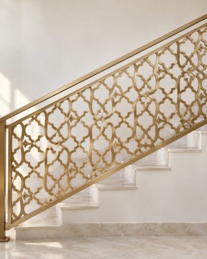 Champagne gold laser-cut steel arabesque staircase railing shown front-facing on a light wall