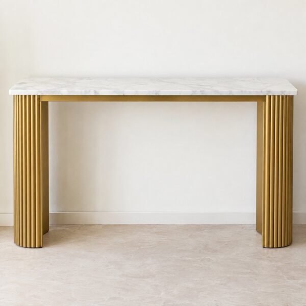 Front view of a fluted gold steel console table with a white marble top against a plain white wall.