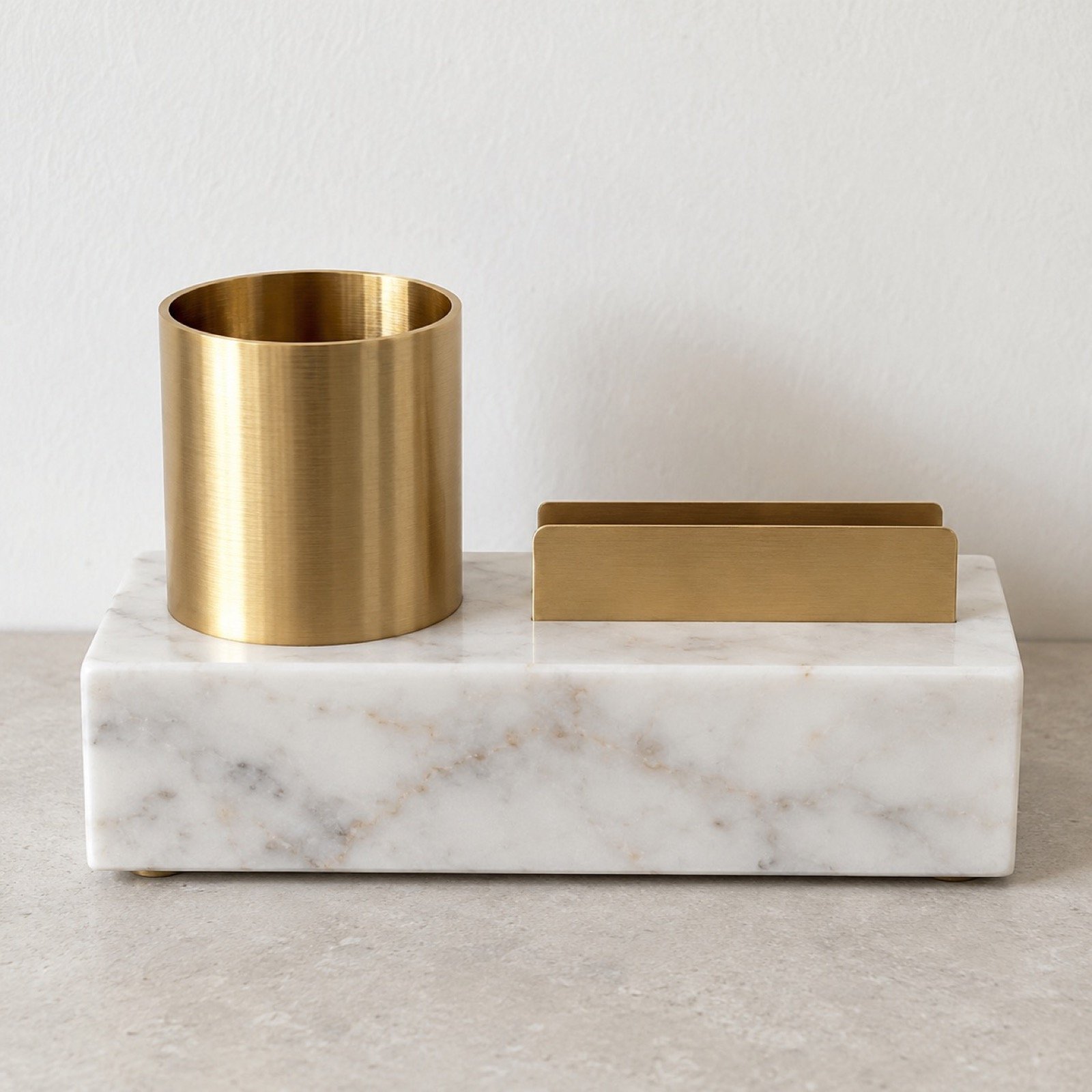 Marble and gold desk organiser with white marble base, gold pen holder and card slot on a plain light background.