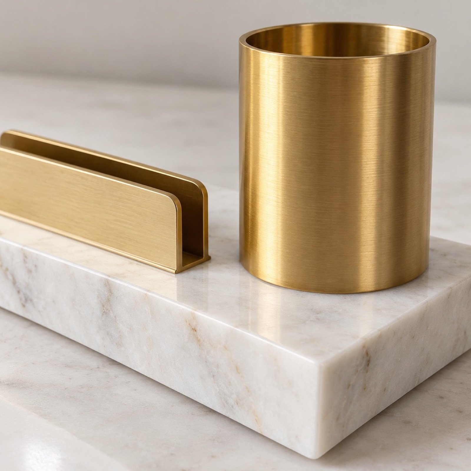 Close-up of the polished white marble edge, natural veining and satin gold steel finish on the desk organiser.