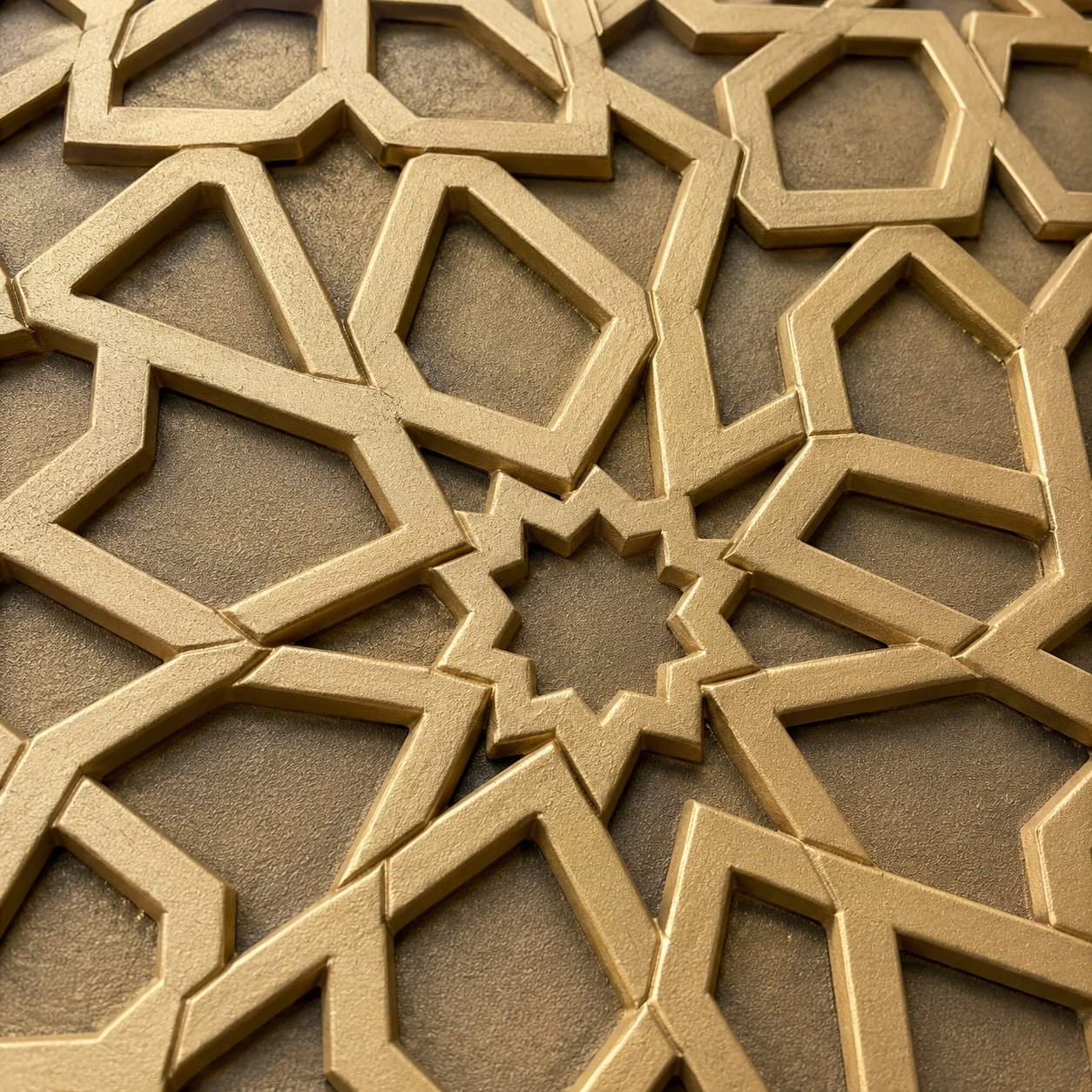 Close-up of crisp cast aluminium Islamic geometric star relief with smooth antique gold powder-coated finish