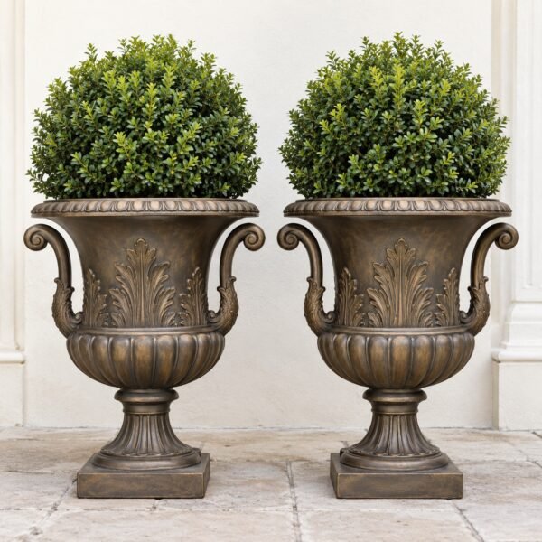 Pair of antique bronze cast aluminium planter urns with handles and acanthus relief on a light background.