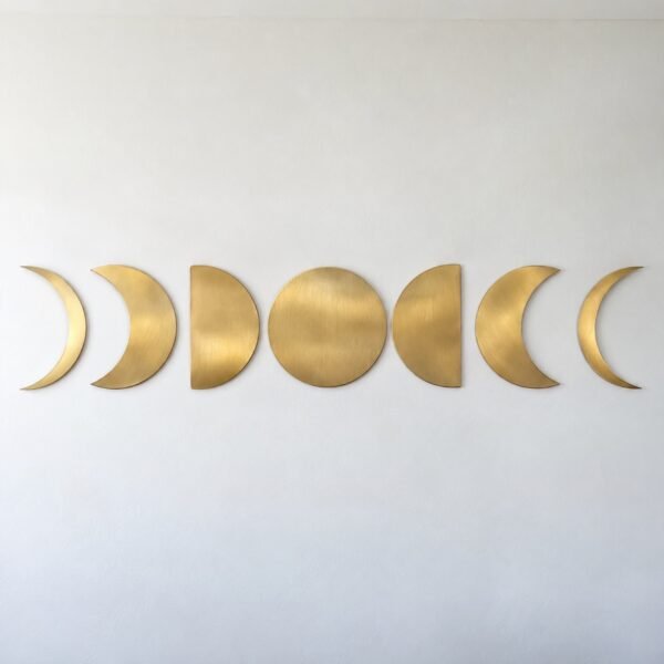 Brushed gold steel Moon Phases wall art with seven lunar discs on a white wall
