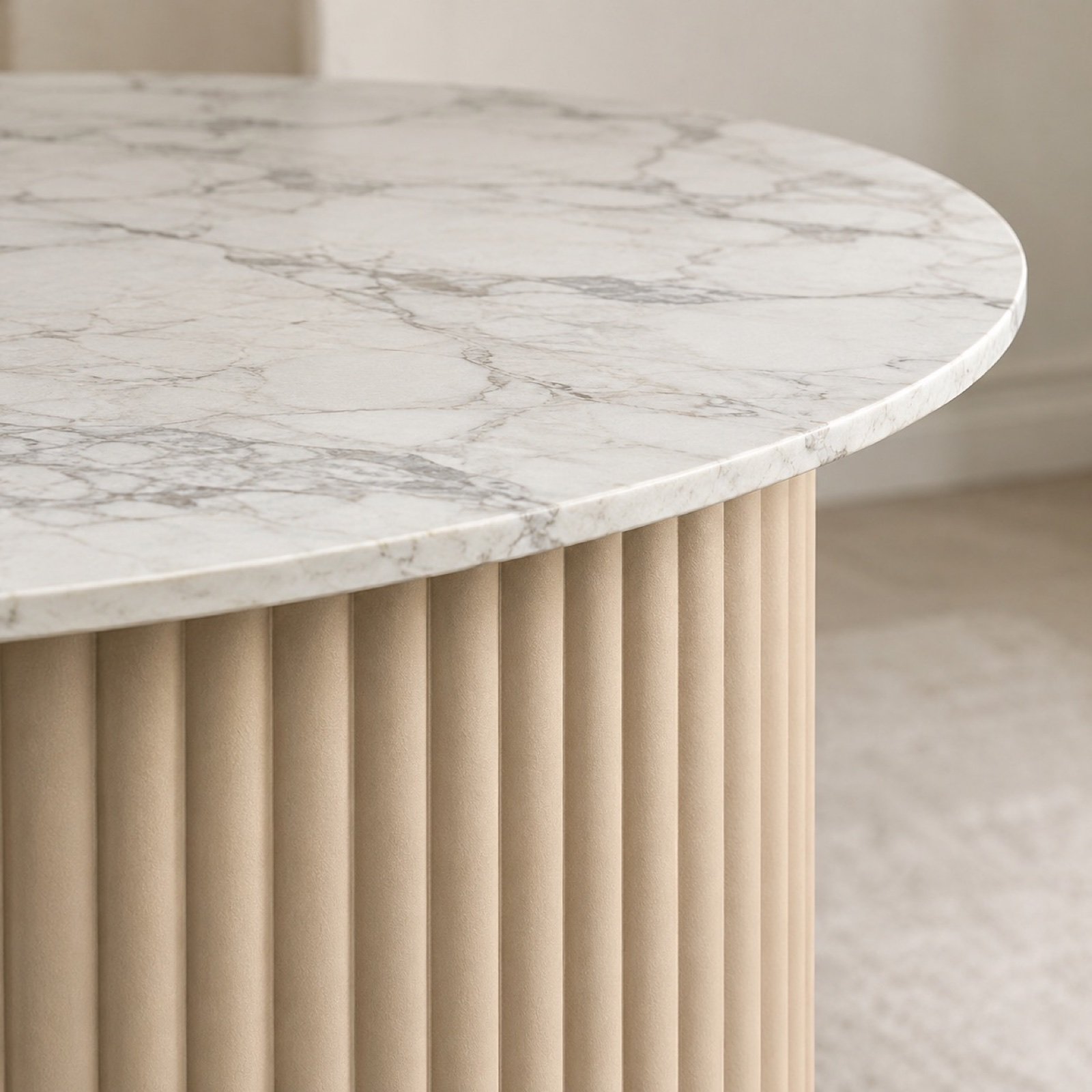 Close-up of the sand-beige fluted pedestal and white-veined sintered stone table edge.