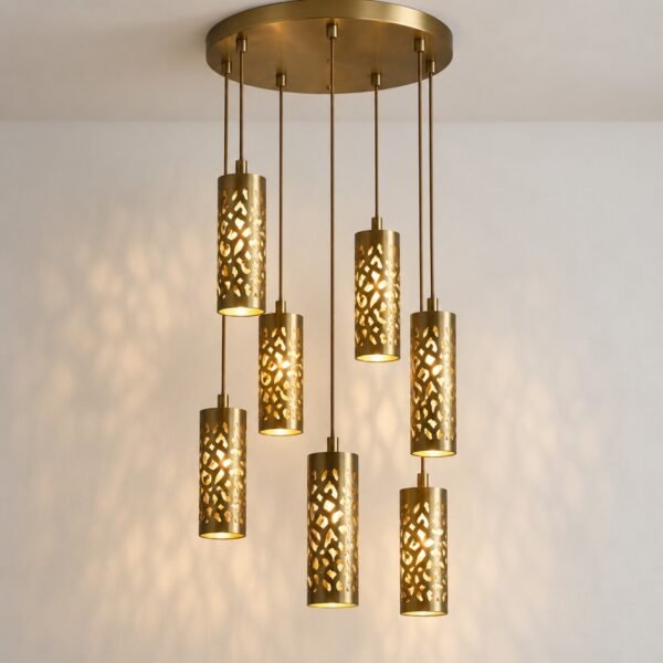 Arabesque pendant cluster with seven staggered brushed brass cylindrical lights on a white wall