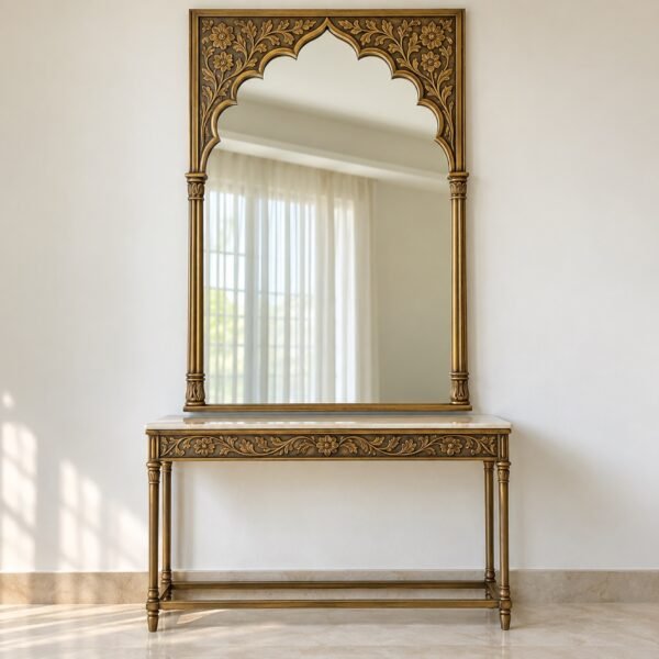 Mughal jharokha arch mirror in an antique-gold metal frame over a console against a plain light wall