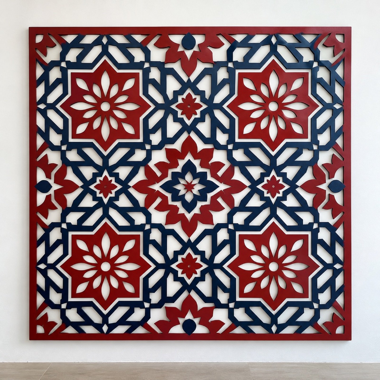 Square crimson and indigo Ajrak-inspired laser-cut steel wall panel on a plain white wall