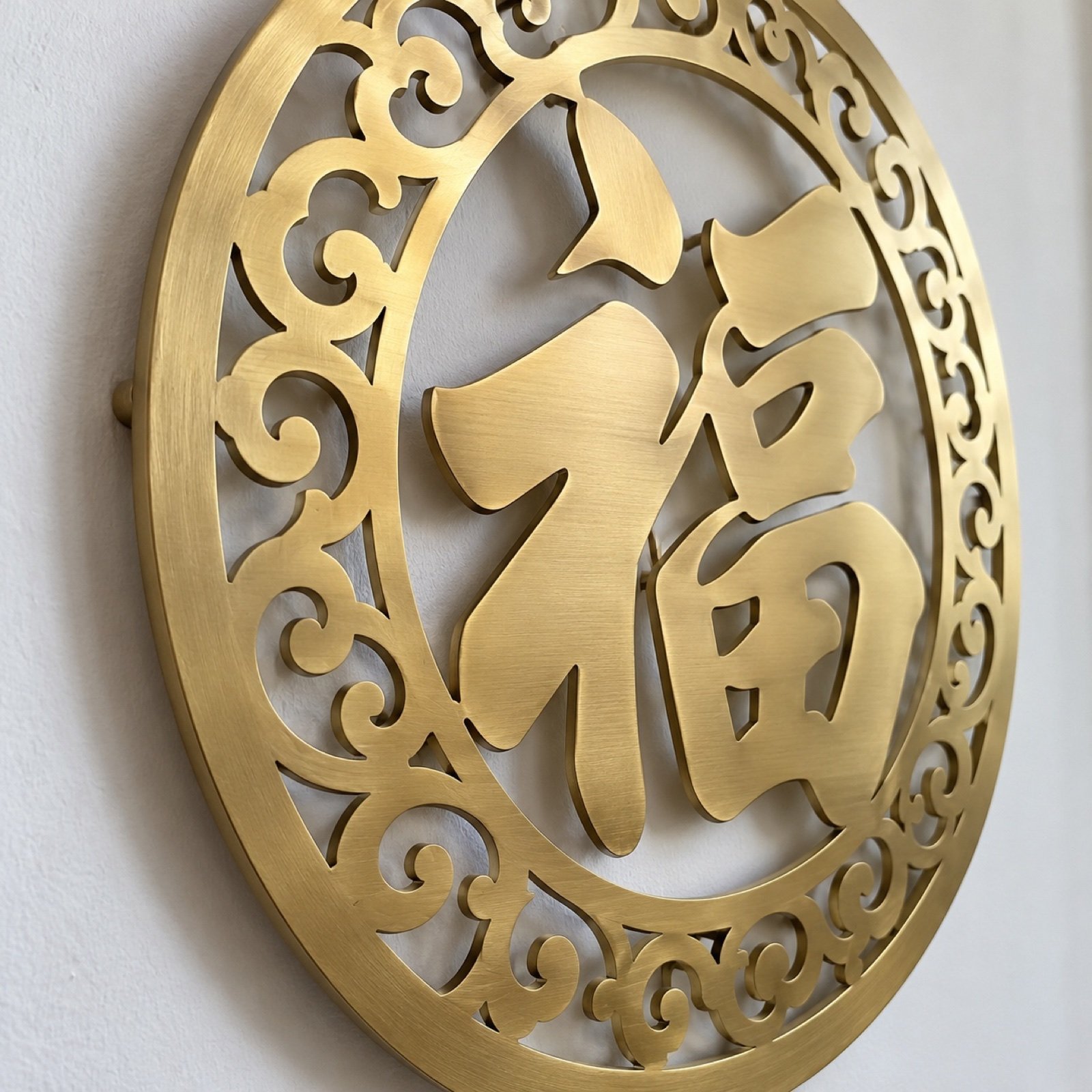 Close-up of the brushed brass edge, cut-out 福, and cloud-scroll border