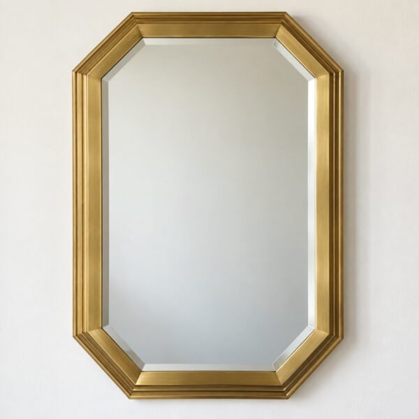 Elongated octagon mirror with stepped brushed brass frame on a plain white wall