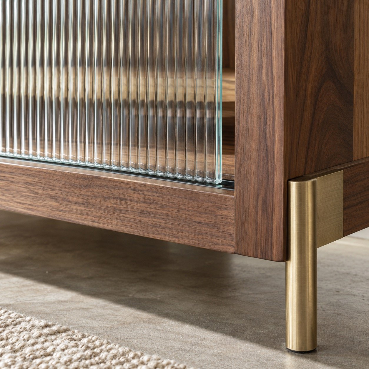 Close-up of F18 clear fluted glass edge, walnut frame, and brushed brass leg