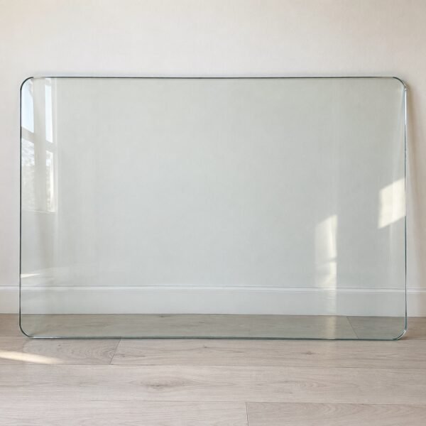 Clear rectangular tempered glass table top with polished bevelled edge against a light wall