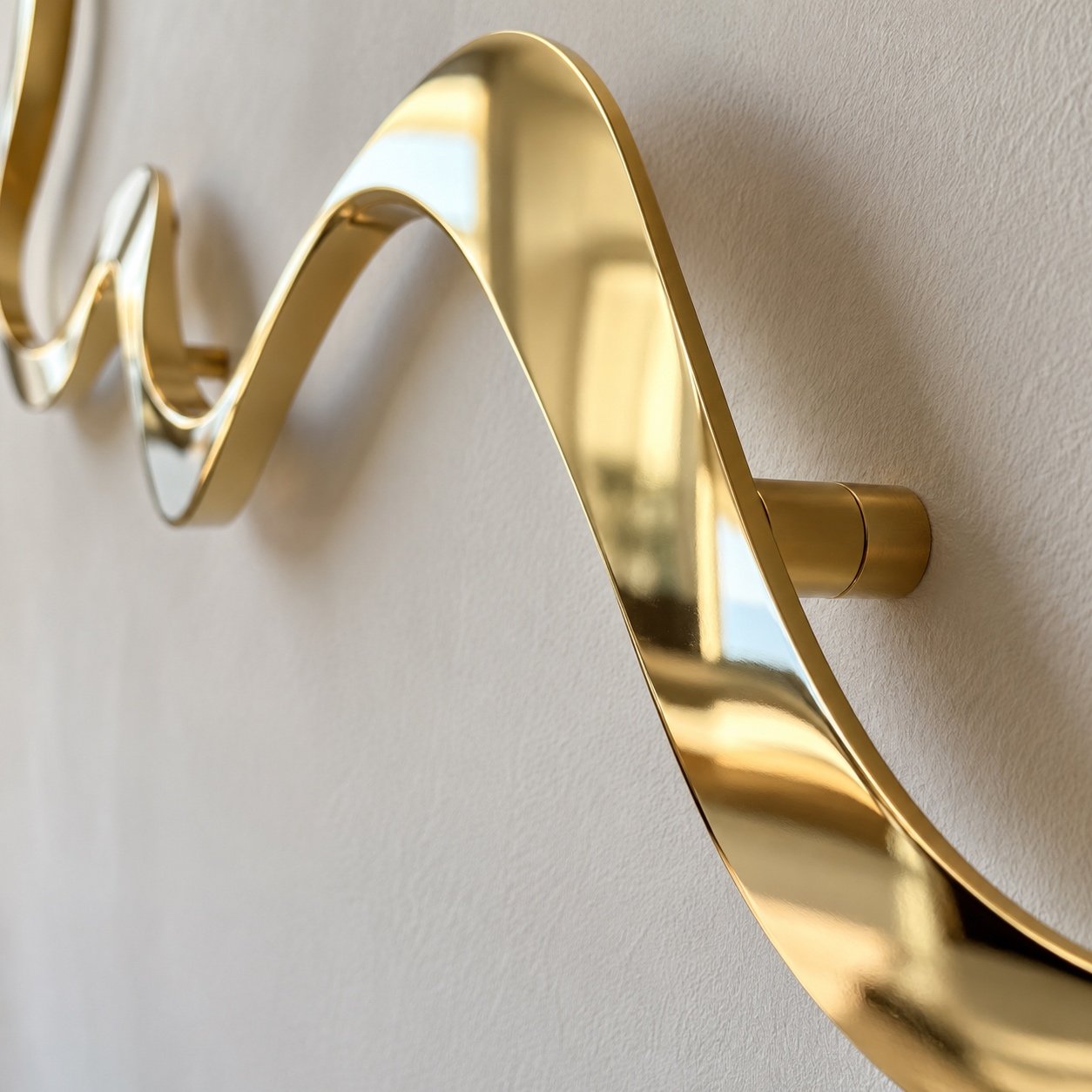 Close-up of the reflective mirror-gold PVD steel edge and finish on liquid line art