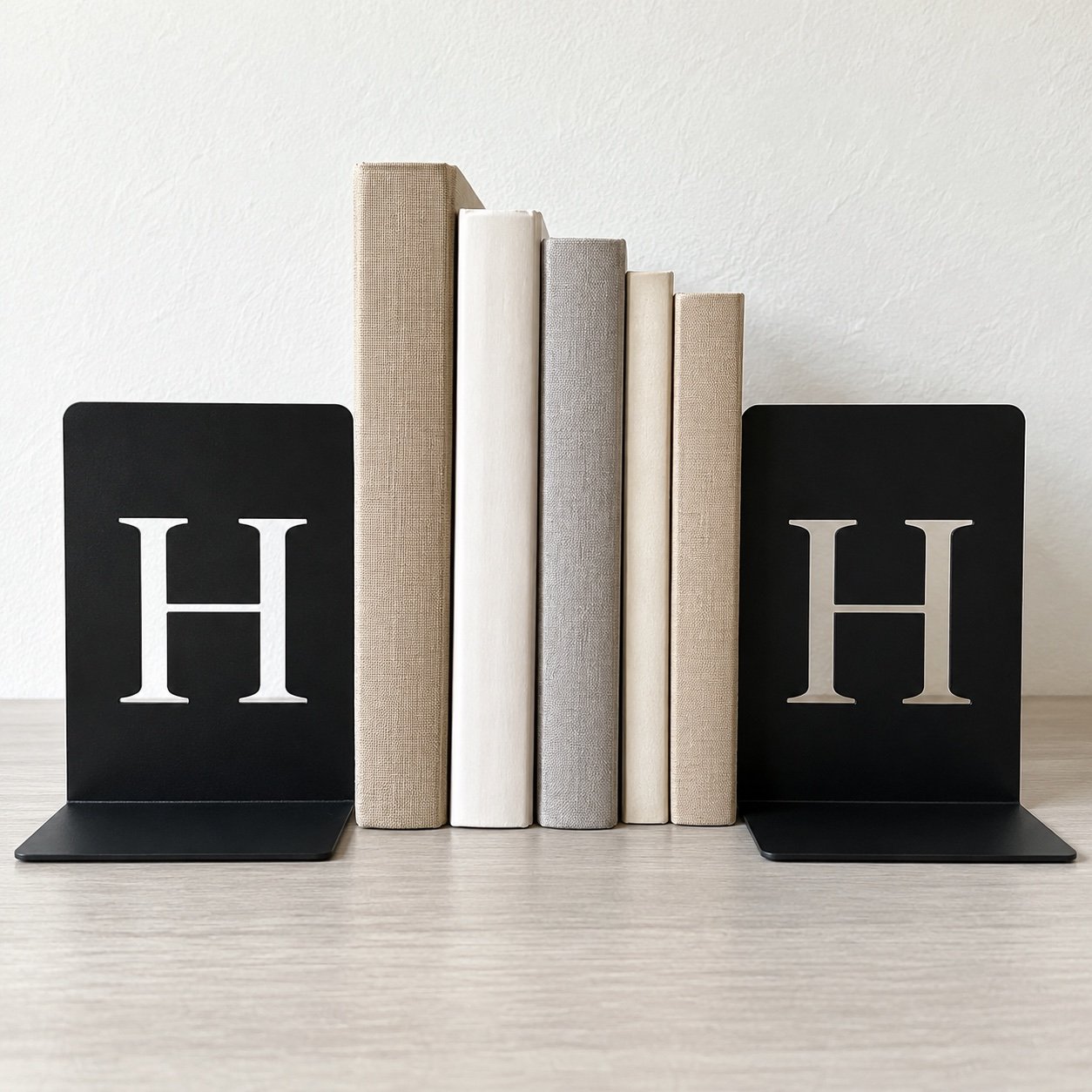 Pair of black steel H monogram bookends shown front-on against a plain white wall.
