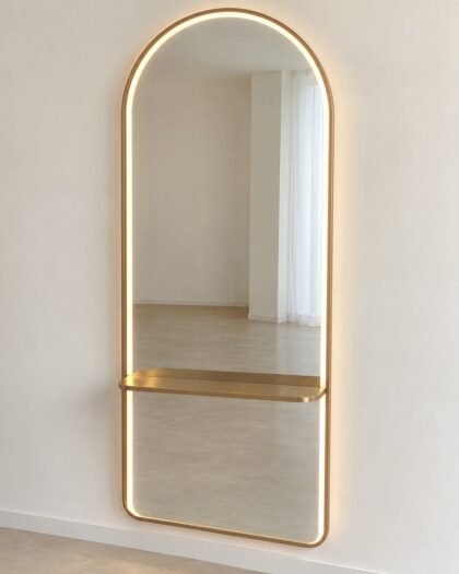 N103 arch-top salon styling mirror with LED edge and small gold shelf on a plain wall.
