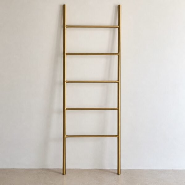 N121 leaning brushed-brass towel ladder against a plain white wall