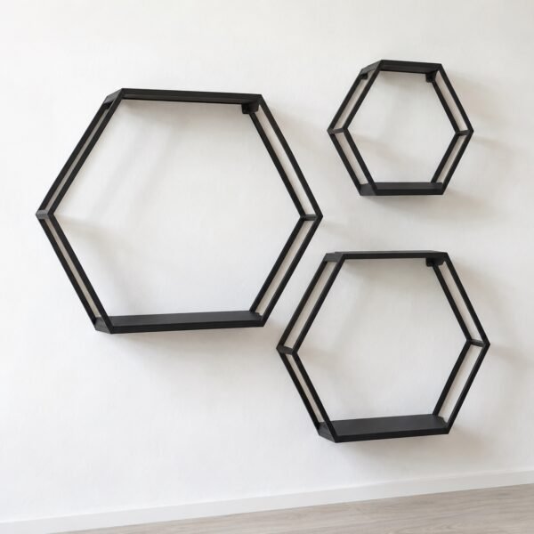 Three matte black steel hexagon wall shelves in graduated sizes on a plain white wall