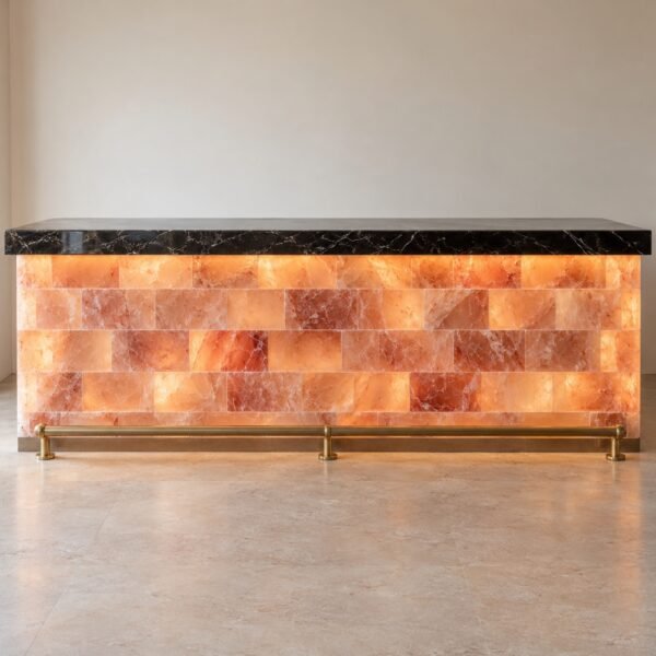 Straight backlit pink Himalayan salt bar counter front with black marble top and brass foot rail