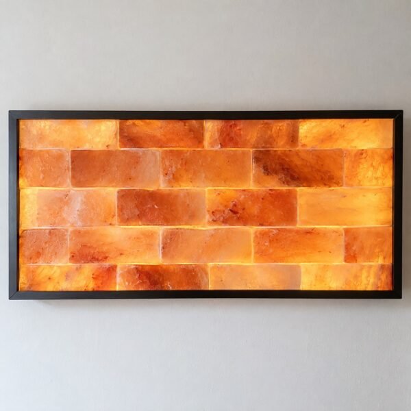 Front view of a rectangular black aluminium frame filled with backlit Himalayan pink salt bricks on a plain white wall