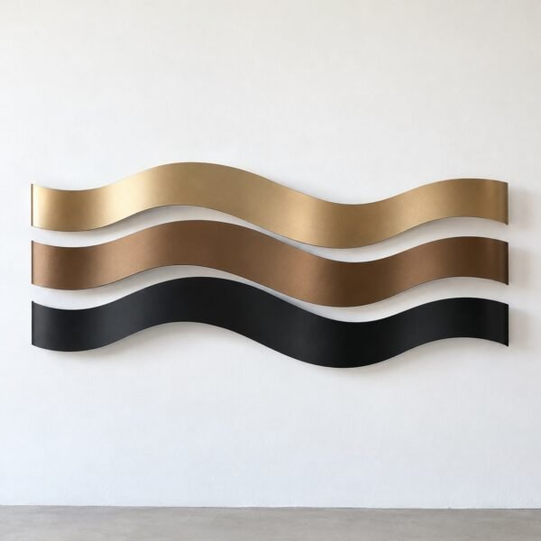 Three stacked wavy steel ribbons in champagne gold, bronze and matte black on a white wall