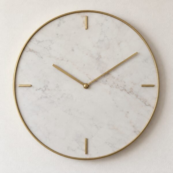 Round white marble wall clock with a thin brass rim and four brass bar markers on a plain white wall.