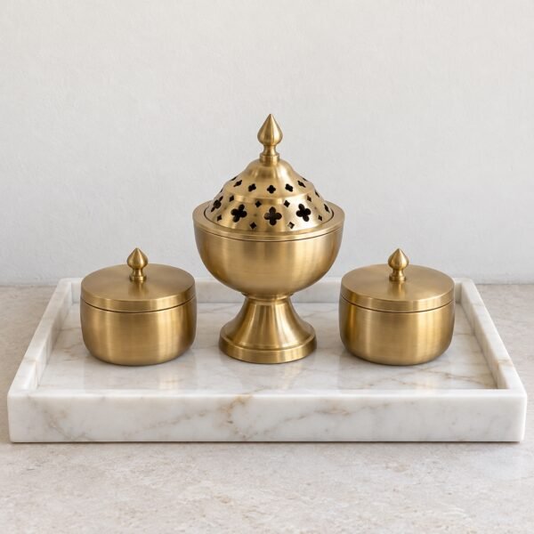 White marble incense and oud set with a brass mabkhara and two lidded brass jars on a tray.