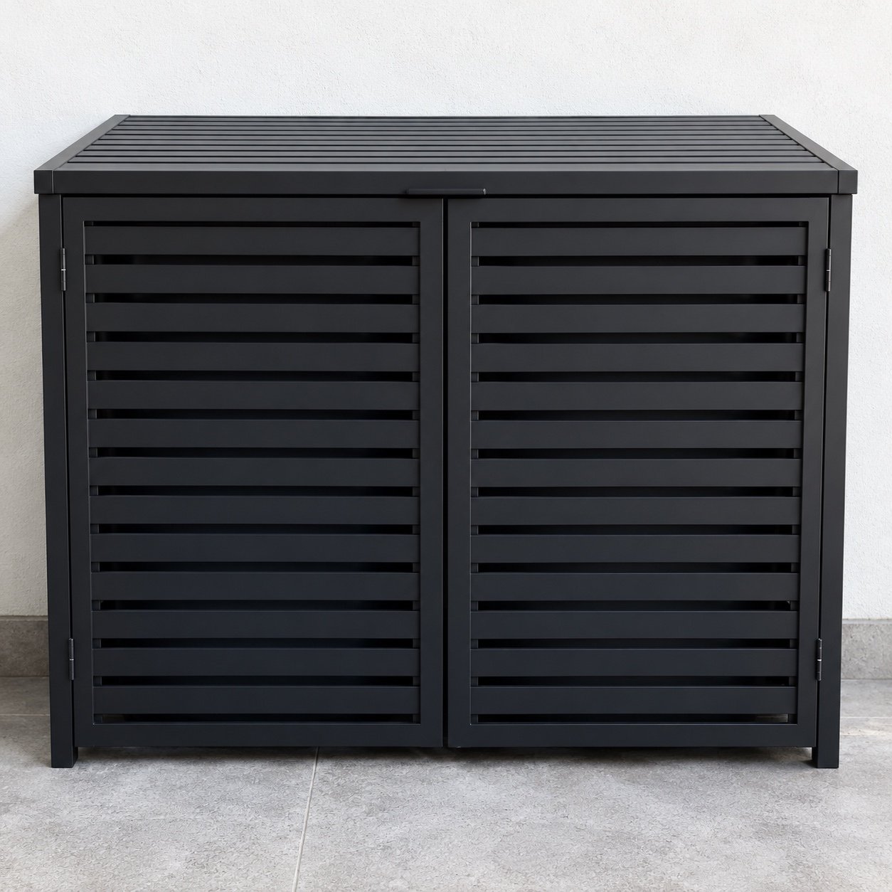 Matte black louvred aluminium wheelie bin enclosure shown straight on against a light wall.