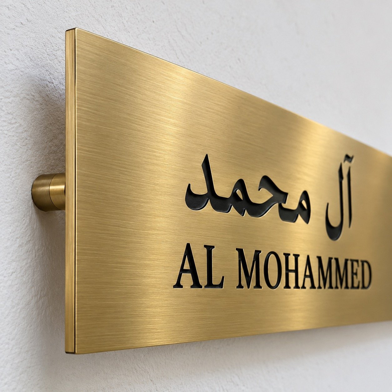 Close-up of the brushed gold PVD stainless steel plate edge, mounting pin and bilingual name.