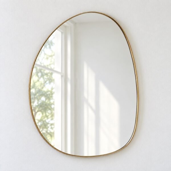 Avela organic warm-gold framed wall mirror on a plain white wall