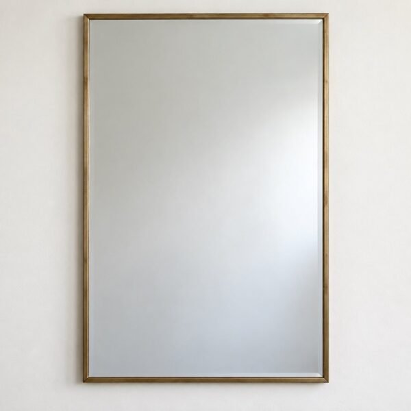 Sahara Frame rectangular wall mirror with a slim warm bronze-gold metal frame on a plain white wall.