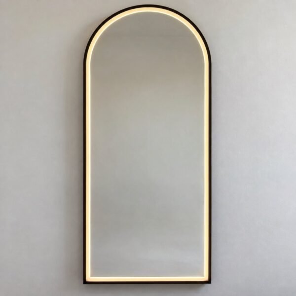 Luma Halo charcoal-black arch wall mirror with warm LED light on a plain white wall