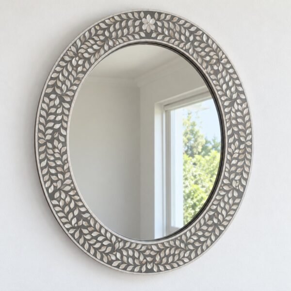 Noura oval wall mirror with a silver-grey botanical mosaic frame on a white wall.