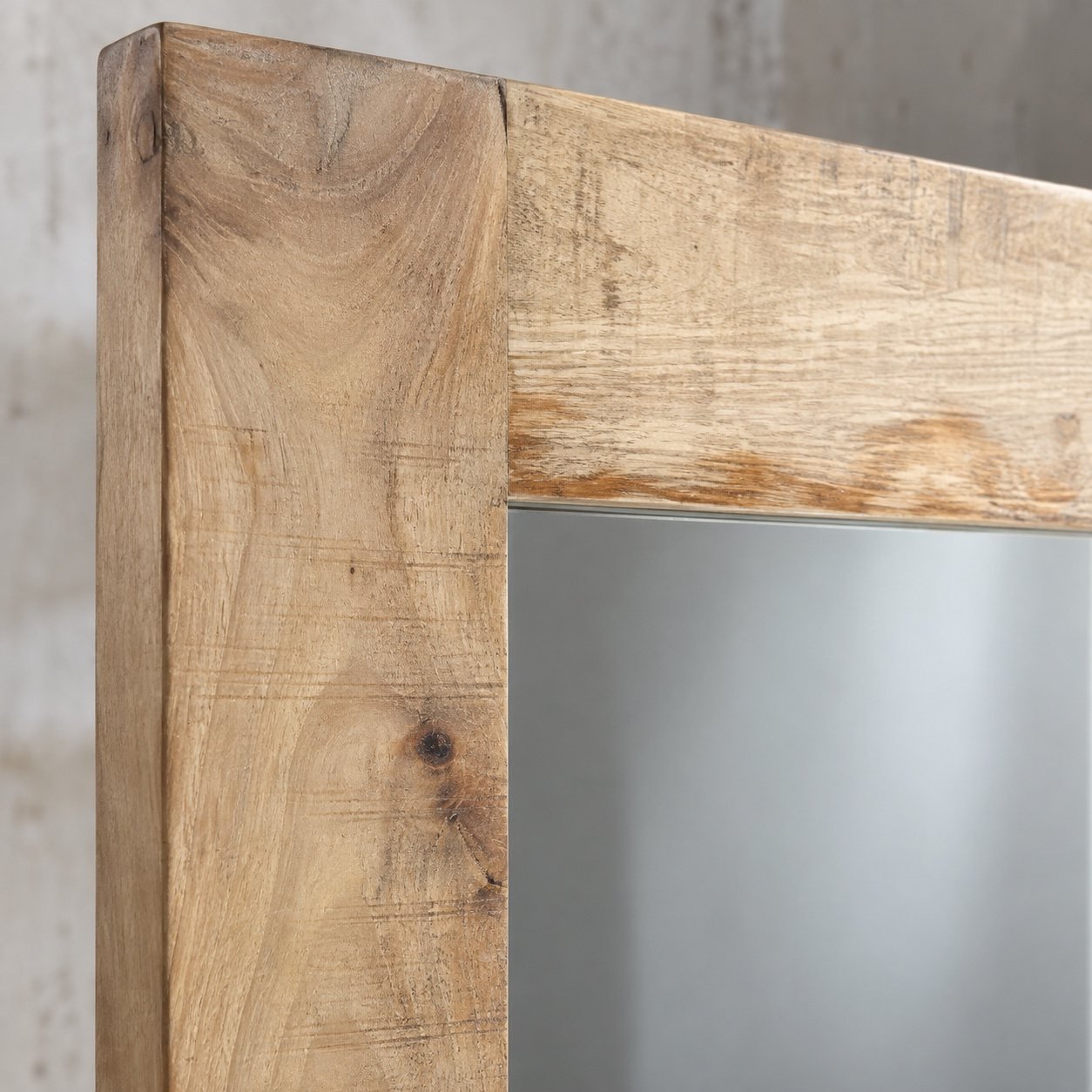 Close-up of the warm beige natural wood frame corner and clean mirror edge of the Haya mirror.