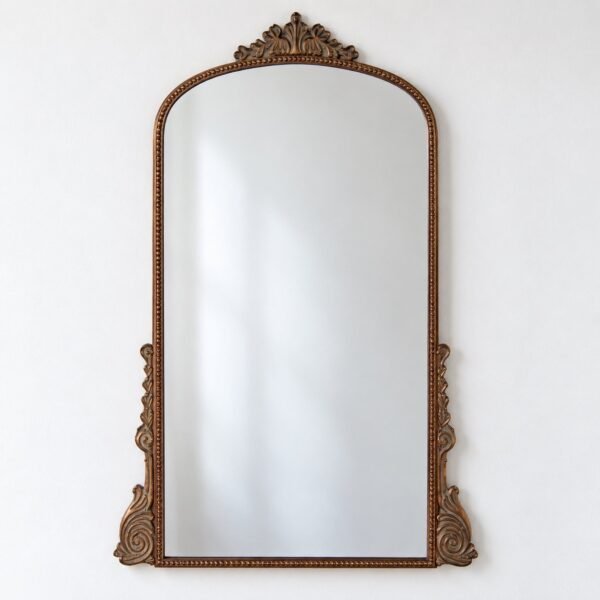 Celestine Crest ornate bronze rectangular wall mirror with rounded arch top on a plain white wall