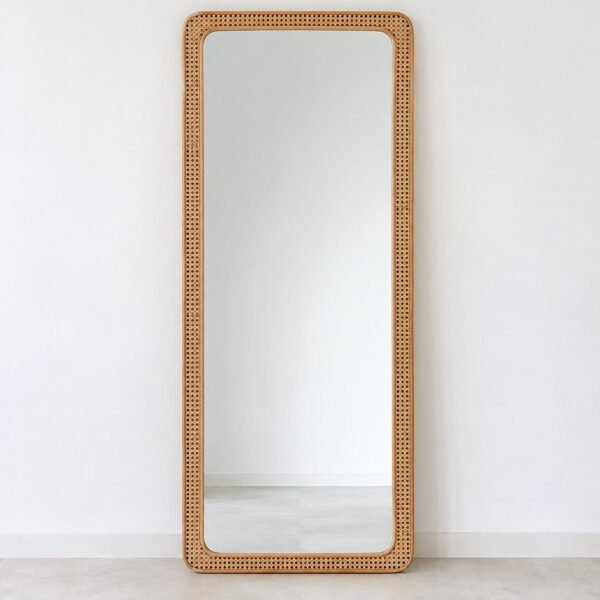 Arden Natural Cane Leaner Mirror with warm honey-beige woven cane frame against a white wall.