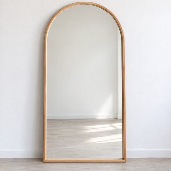 Luma Haven light natural wood arch leaner mirror standing against a plain white wall