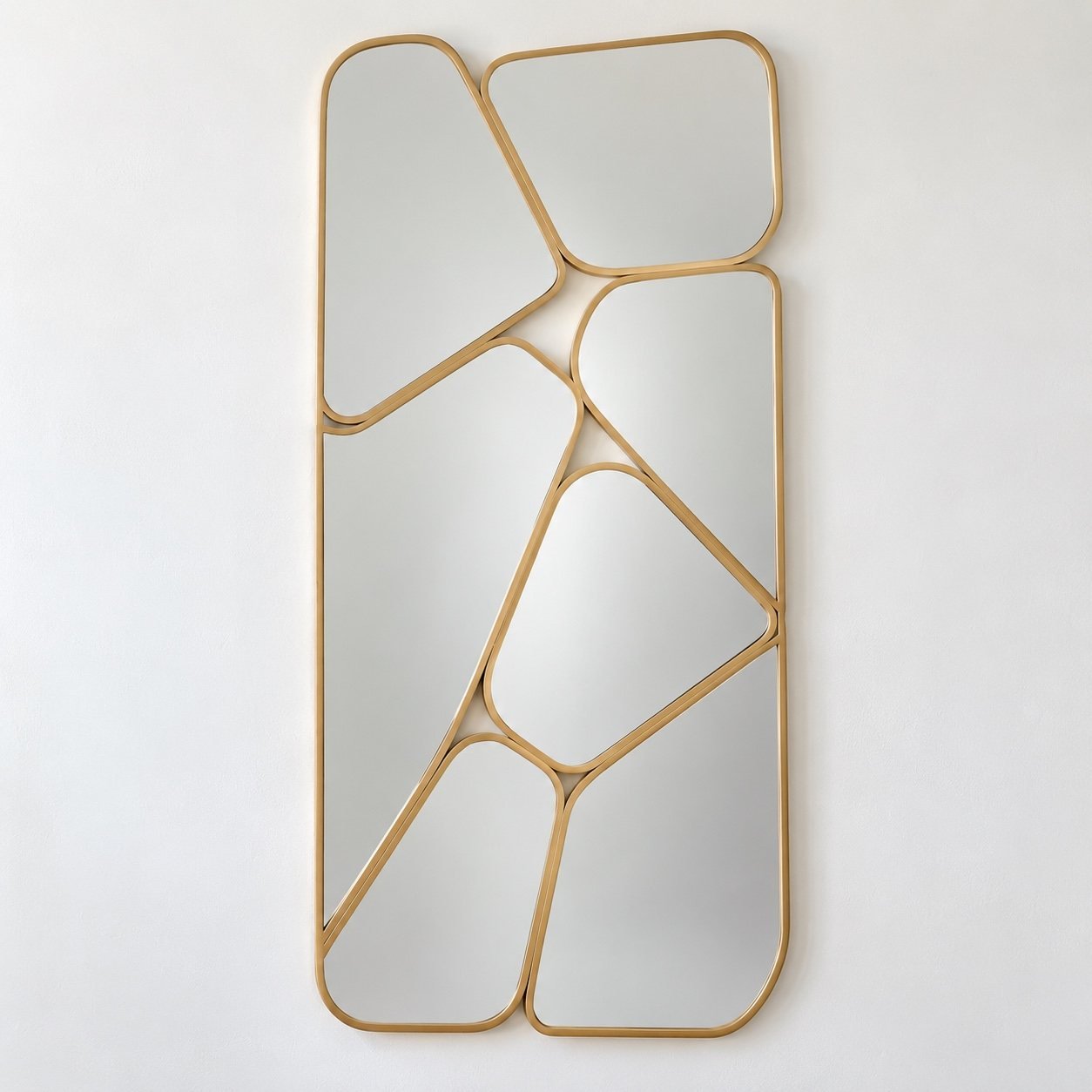 Nahla organic multi-panel wall mirror with slim warm champagne-gold metal frame on a plain white wall.
