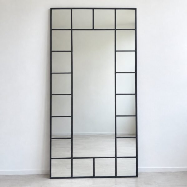 Rimal dark charcoal grid leaner floor mirror standing against a plain white wall