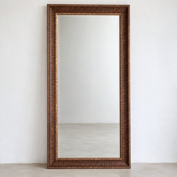 Zayna rectangular walnut-brown wood frame leaner mirror standing against a plain white wall