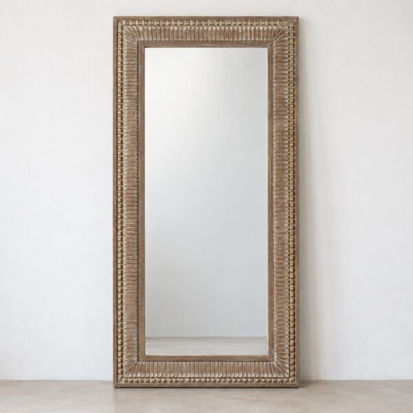 Safa Frame tall rectangular leaner mirror on a plain white wall and pale floor, front view.