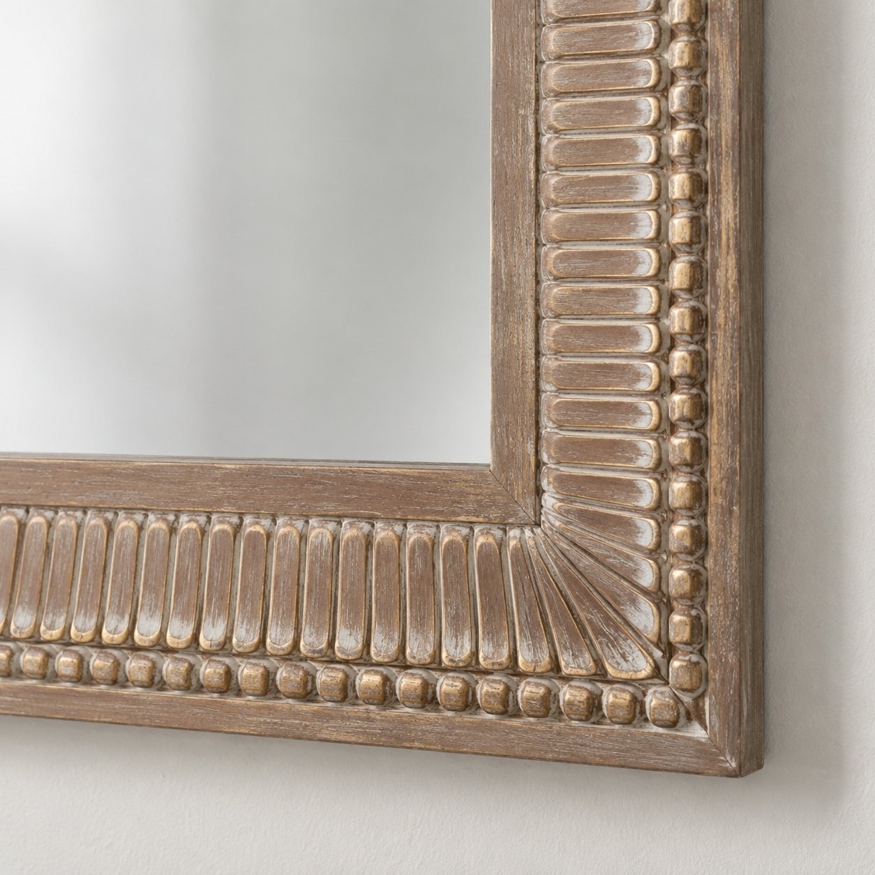 Close-up of the Safa Frame carved wooden corner, rubbed detailing, and clean mirror edge.