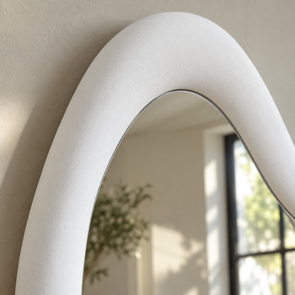 Close-up of the smooth matte white frame corner and clean mirror edge of Noor floor mirror.