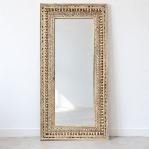 Noura Ivory Carved Rectangle full-length leaner mirror against a plain white wall.