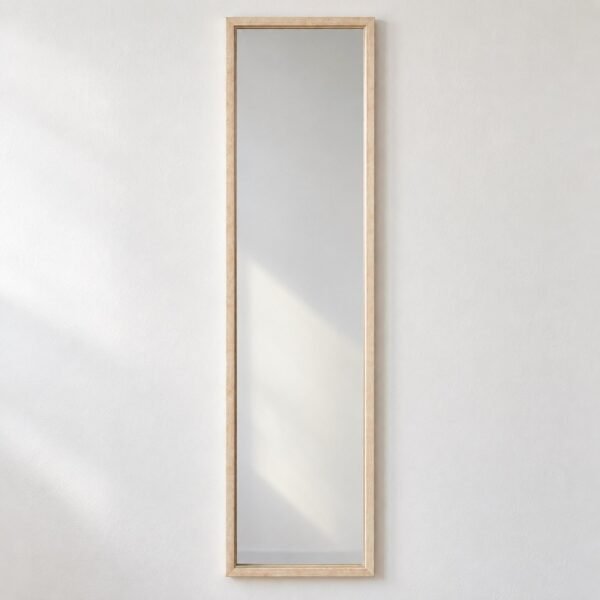 Nivara tall rectangular wall mirror with a slim light natural wood frame on a plain white wall.