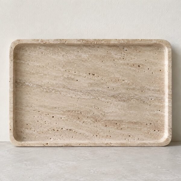Front view of a beige natural travertine vanity tray with softly rounded corners on a light floor.