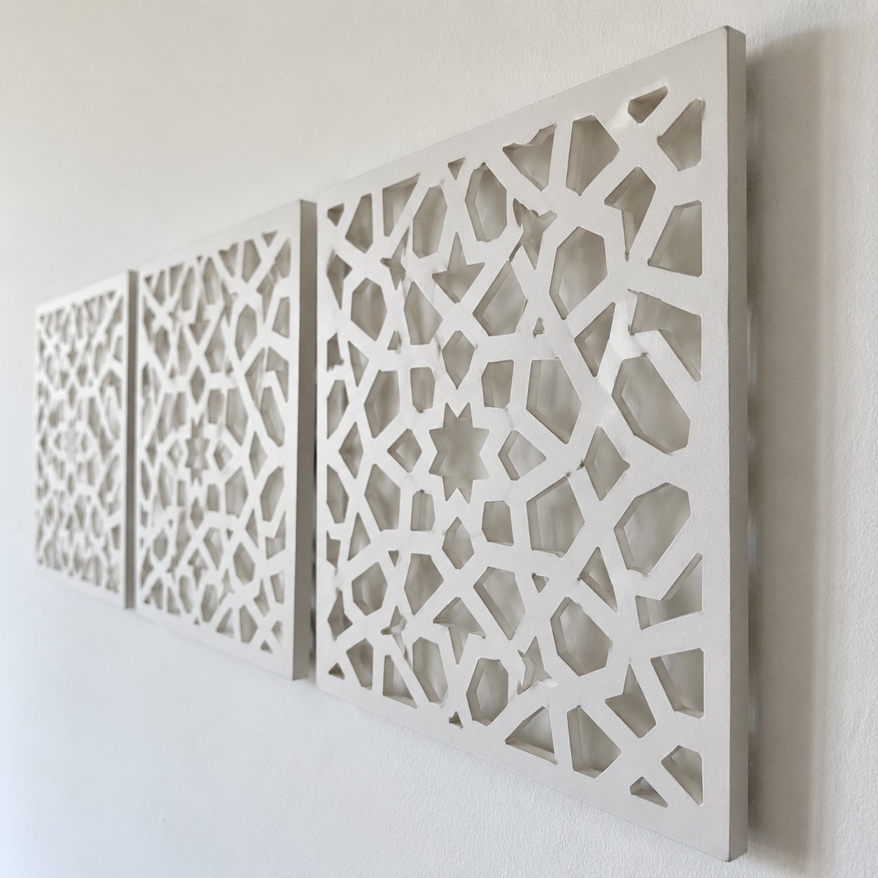 Close-up of the matte powder-coated aluminium edge and geometric cutwork on a white Mashrabiya wall panel.