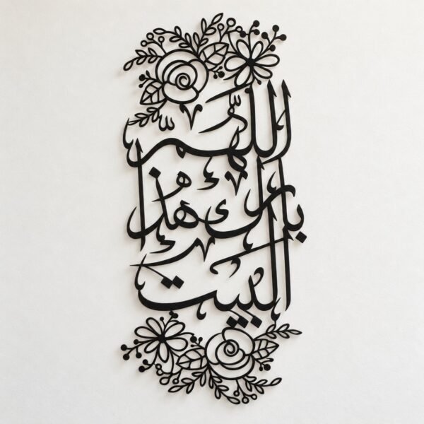 Black metal Arabic calligraphy wall art with floral cut-outs on a warm-white wall.